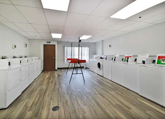 A laundromat with a red chair in the middle of the room.