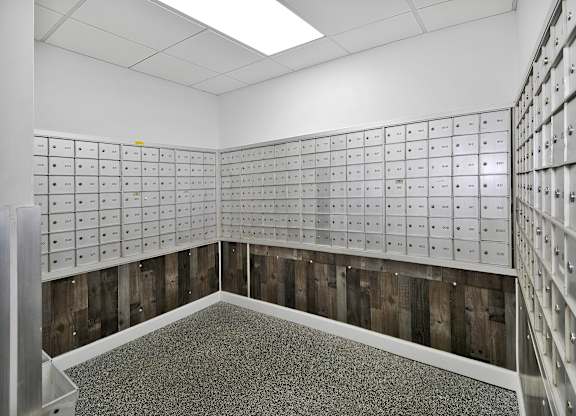 A room with a lot of mailboxes on the wall.
