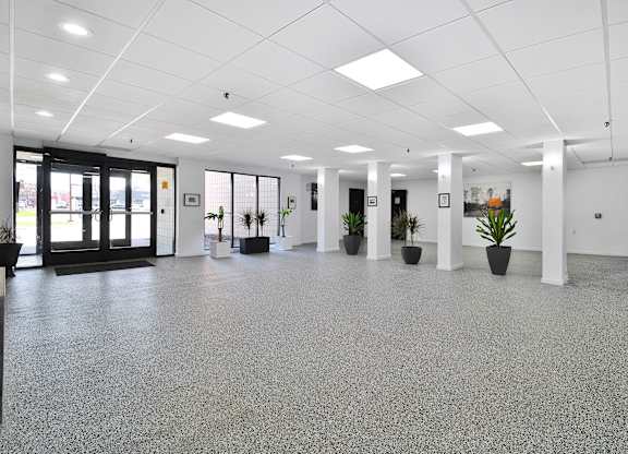 A spacious office with grey flooring and white walls.