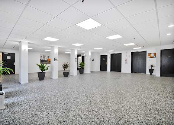 A spacious office lobby with a grey floor and white walls.