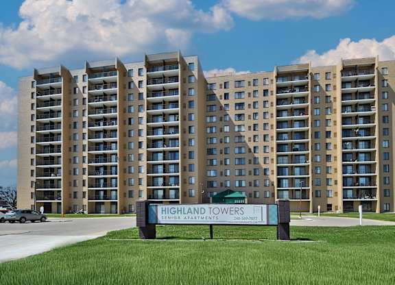 The Highland Towers senior apartment complex is a large building with a sign in front of it.