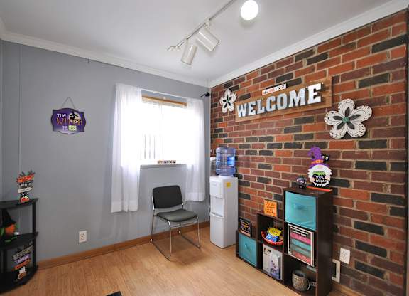A room with a brick wall and a sign that says "Welcome".
