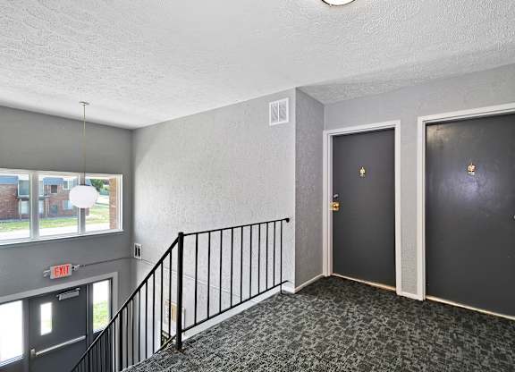 A hallway with two doors and a staircase.