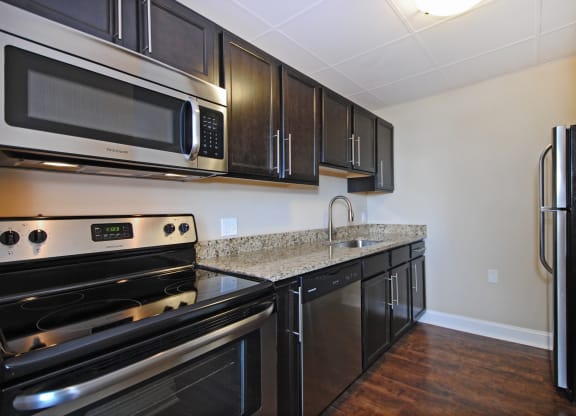 Kitchen with Stainless Steel Appliances, Dishwasher, cabinet space, and hardwood floors at Bancroft Apartments in Saginaw, MI