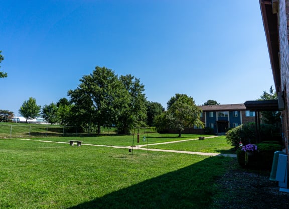 Large courtyard with sidewalks and benches at Golf Manor Apartments in Roseville, Michigan