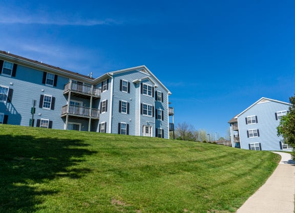 Sidewalk and apartment building on hill with view. Apartments for rent in Kalamazoo, MI near WMU Western Michigan University