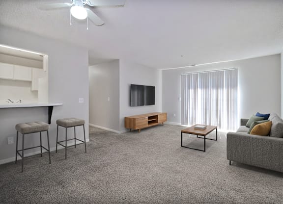 A living room with a grey carpet and furniture.