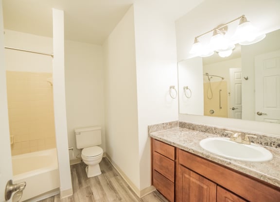 Renovated Bathroom with granite counter tops and wood flooring at Westwind Townhomes in Lansing, Michigan