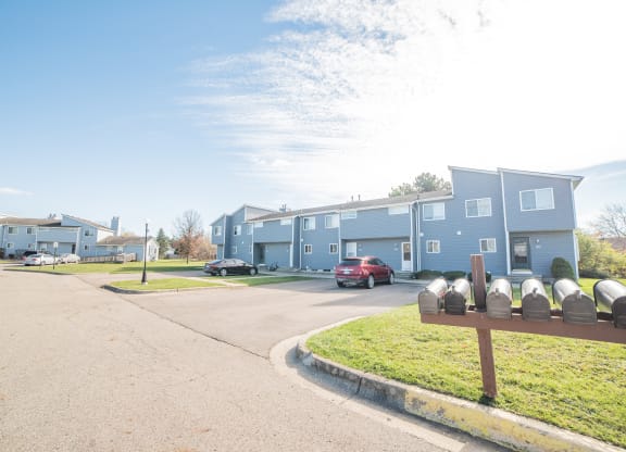 Building exteriors, parking spaces, and easy access mailing at Westwind Townhomes in Lansing, Michigan