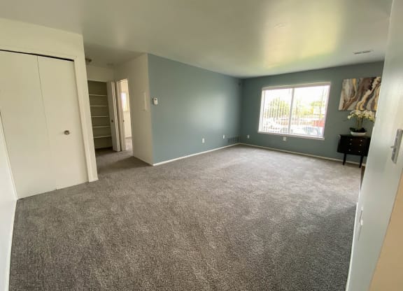Spacious living room with window and hallway to other rooms, at Gale Gardens Apartments