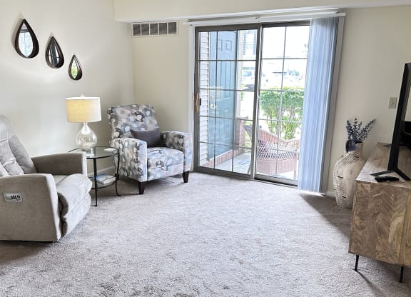 a living room with two chairs and a sliding glass door