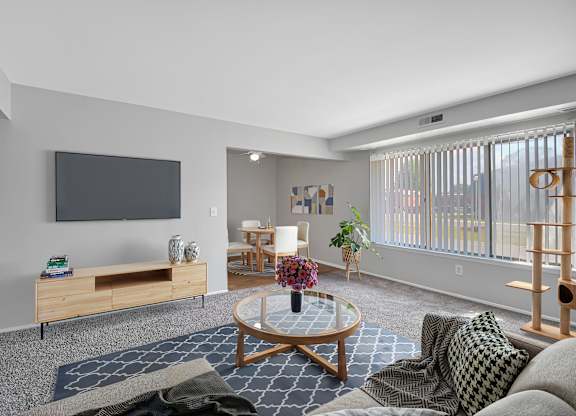 A living room with a flat screen TV mounted on the wall.