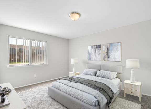 A bedroom with a large bed and two lamps.