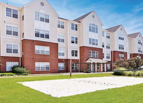 an exterior view of an apartment building with a yard