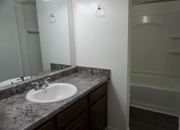 Bathroom with granite countertops at Woodcrest Apartments in Westland, Michigan