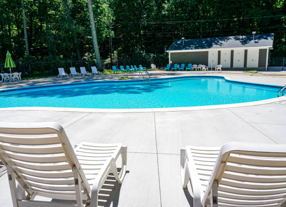 Swimming pool and pool chairs at Woodcrest Apartments in Westland, Michigan