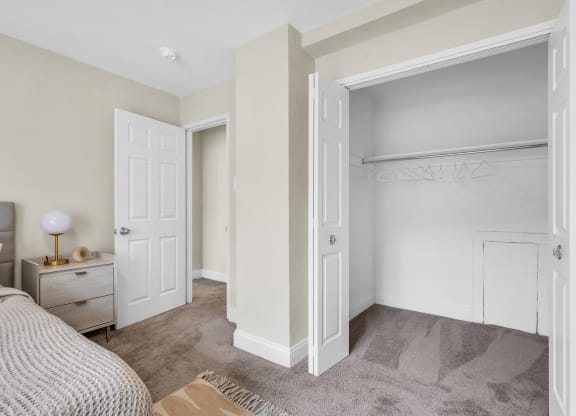 a bedroom with an open closet and a bed with white doors  at Parkview Towers, Collingswood, 08107