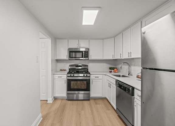 A kitchen with a stainless steel refrigerator, stove, and oven.