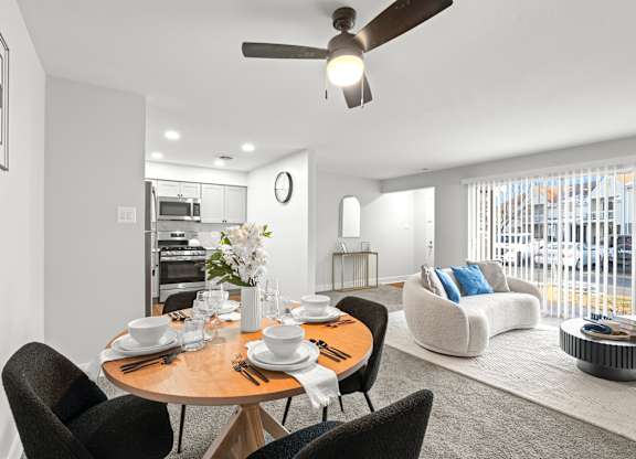 A modern dining room with a round table set for four.