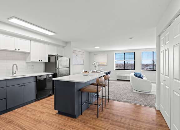A modern kitchen with a large island and a dining area.