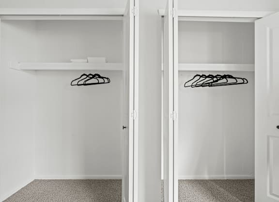 A white closet with two doors and a shelf.
