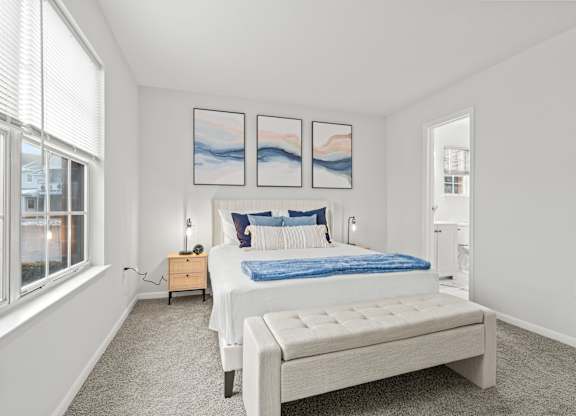 A bedroom with a large bed and a window.
