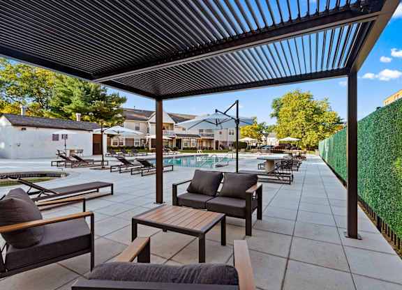 A patio with a table and chairs under a roof.
