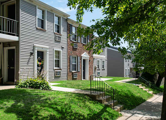A row of houses with green lawns in front.