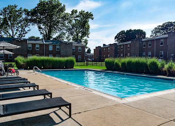 a swimming pool in front of a brick apartment building