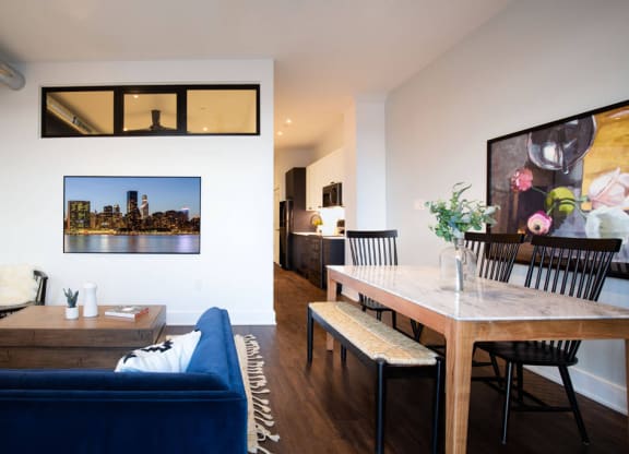 a living room and dining room with a blue couch and a wooden table at The Irvine, Philadelphia, PA