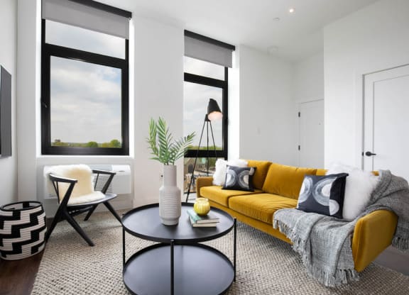 a living room with a yellow couch and a table at The Irvine, Philadelphia