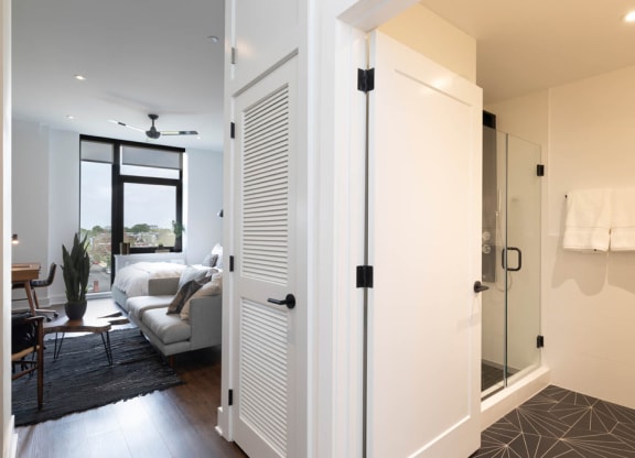 a living room with a door to a bathroom and a couch at The Irvine, Philadelphia, PA