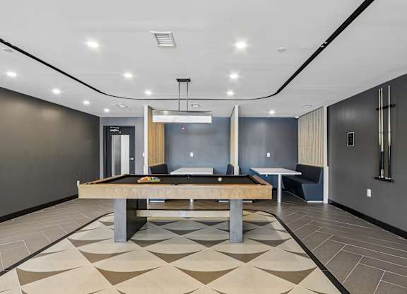 A room with a pool table and a bench.