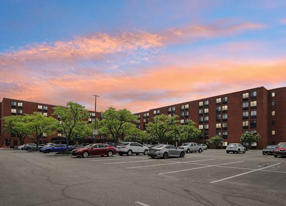 A parking lot with cars and a building in the background.