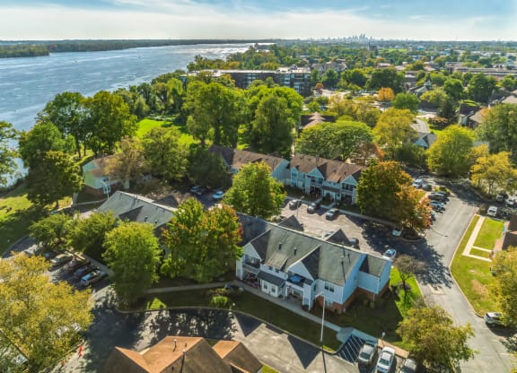 an aerial view of a neighborhood of houses with a river in the background
