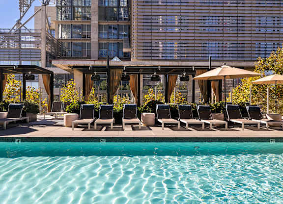 Pool area with lounge chairs at K1 Apartments, California