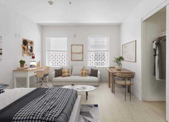 A bedroom with a bed, desk, and chair.