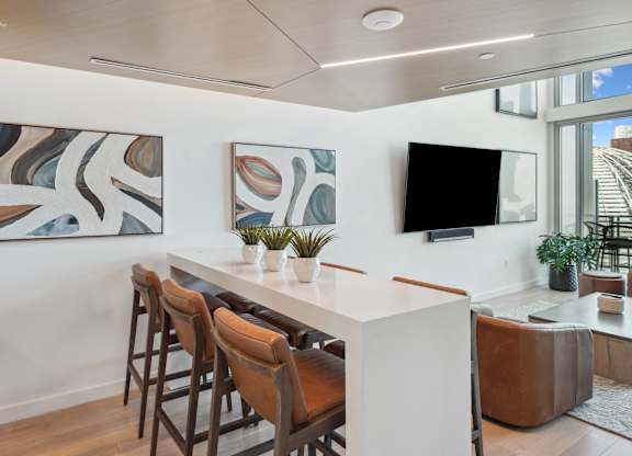 Living room with a white table and chairs and a tv on the wall at K1 Apartments, San Diego, California