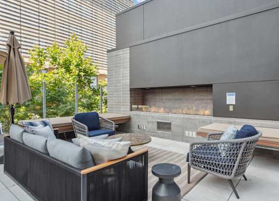 Living room with couches and chairs and a fireplace at K1 Apartments, California
