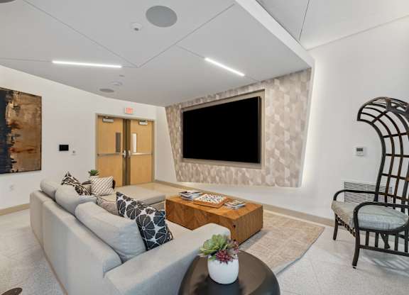 Living room with a couch and a television on the wall at K1 Apartments, San Diego, California