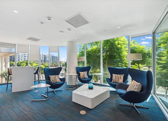 Living room filled with blue chairs at K1 Apartments, San Diego, California