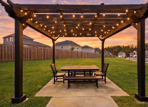 Backyard pergola with integrated lighting creates a warm, inviting outdoor setting.