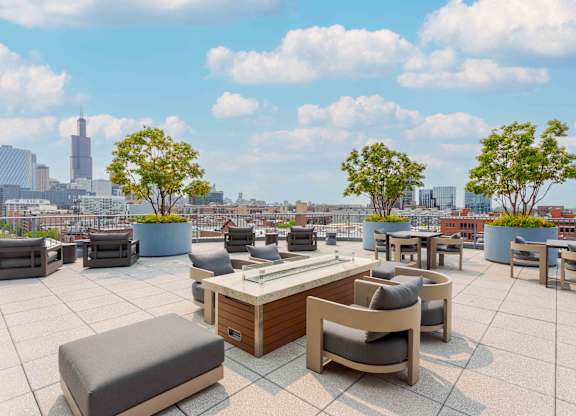A rooftop patio with a table and chairs overlooking a city skyline.