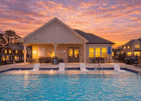 A house with a pool in front of it.