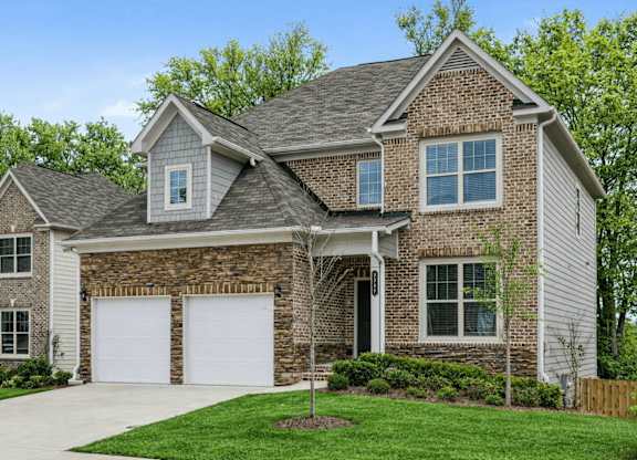A house with a grey roof and white garage doors.