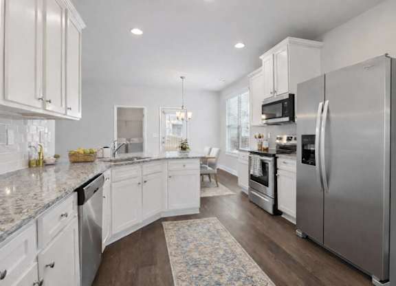A kitchen with white cabinets and a large island.