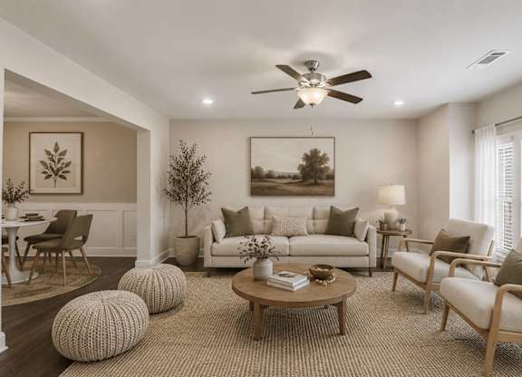 A living room with a white couch, a coffee table, and a painting on the wall.
