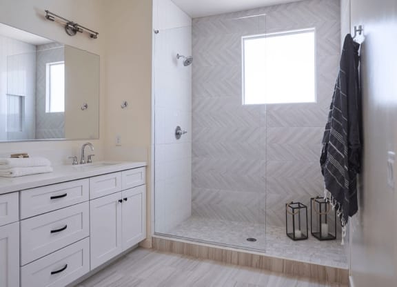 a white bathroom with a shower and a sink and a mirror at Novella Biltmore, Arizona