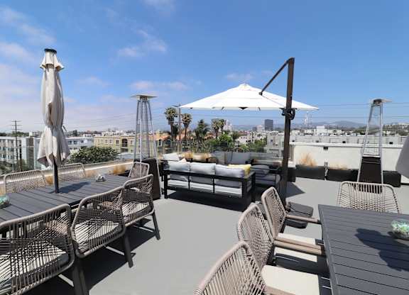 A patio with chairs and umbrellas overlooking a cityscape.
