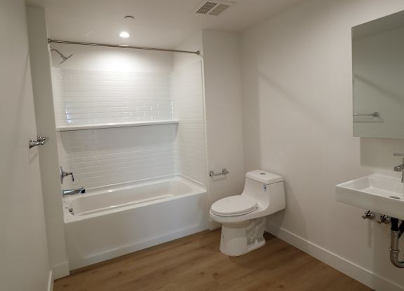 A white bathroom with a toilet, sink, and bathtub.